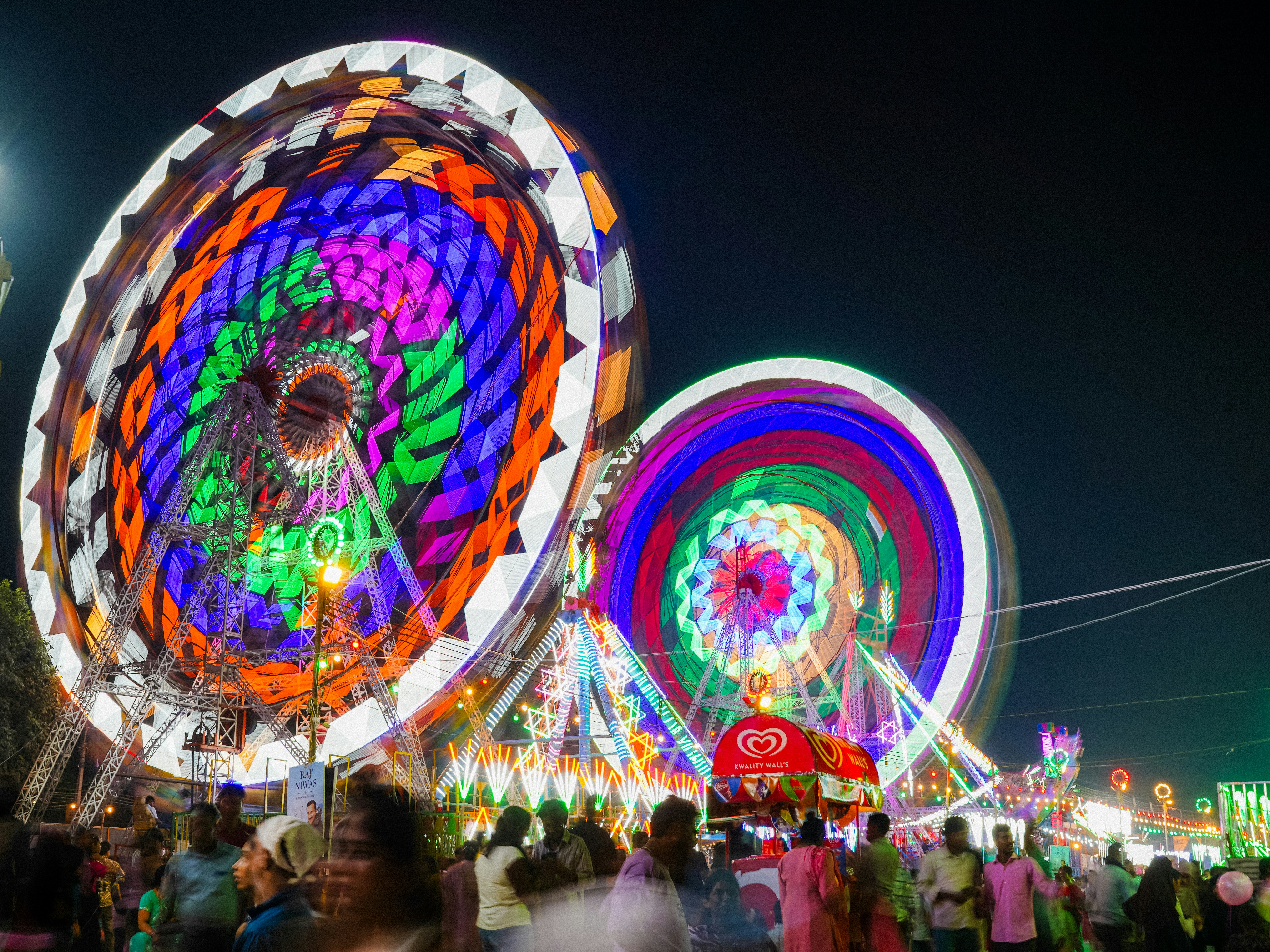 Brightly lit ferris wheel at a nighttime carnival